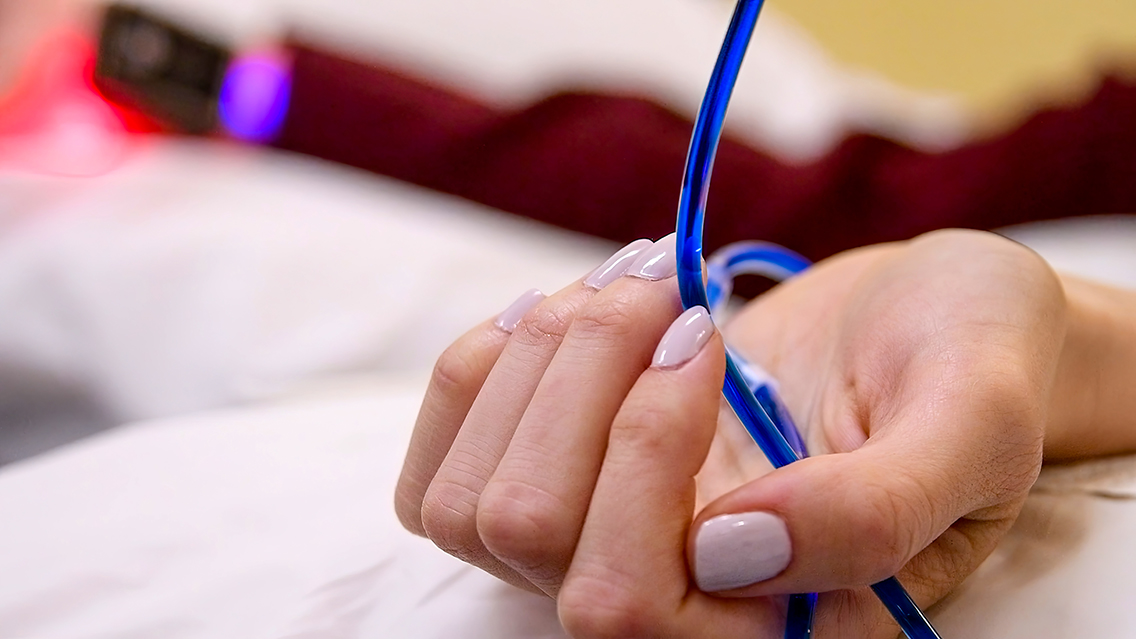 Close-up of the IV line in the patient's hand during a methylene blue treatment